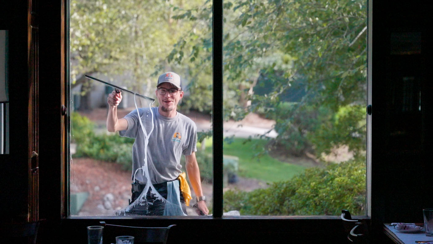 A Window Ninjas team member cleaning the outside of a window.